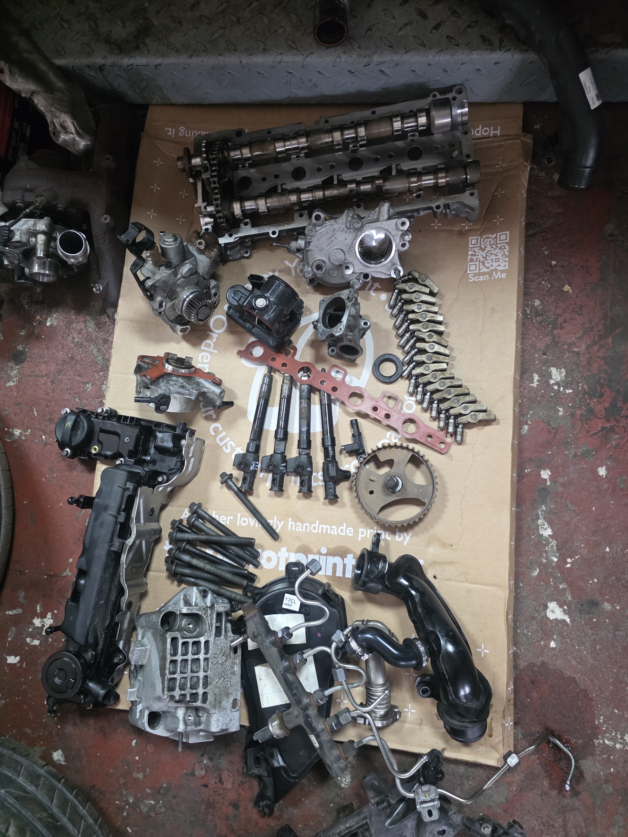 Engine parts laid out in order on cardboard after a strip-down